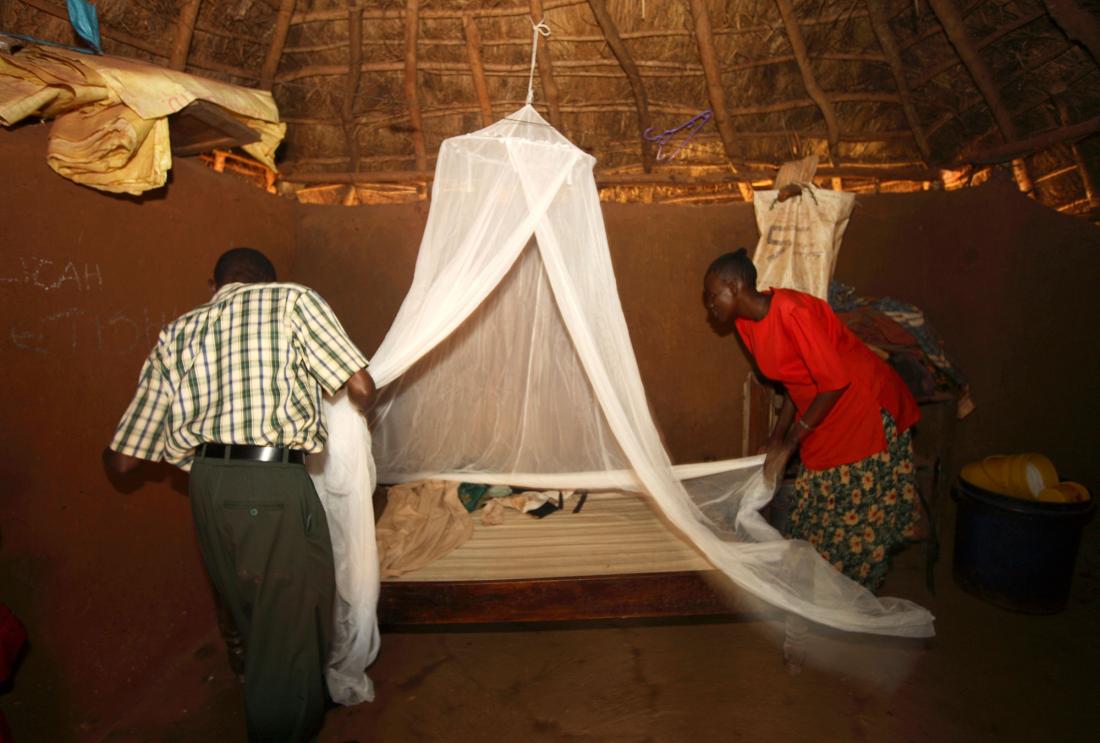 Man and woman assembling a bed net in rural Kenya.