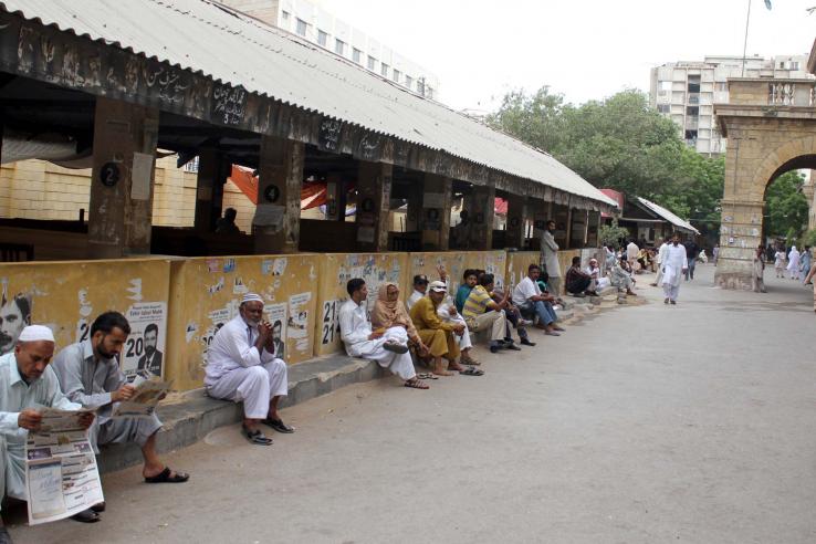 People wait outside a city court in Pakistan