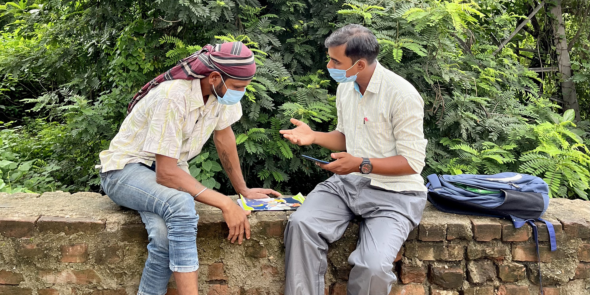 Two men sitting on together talking; a survey is taking place