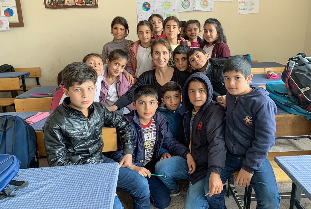 Sule Alan standing next to students in a classroom