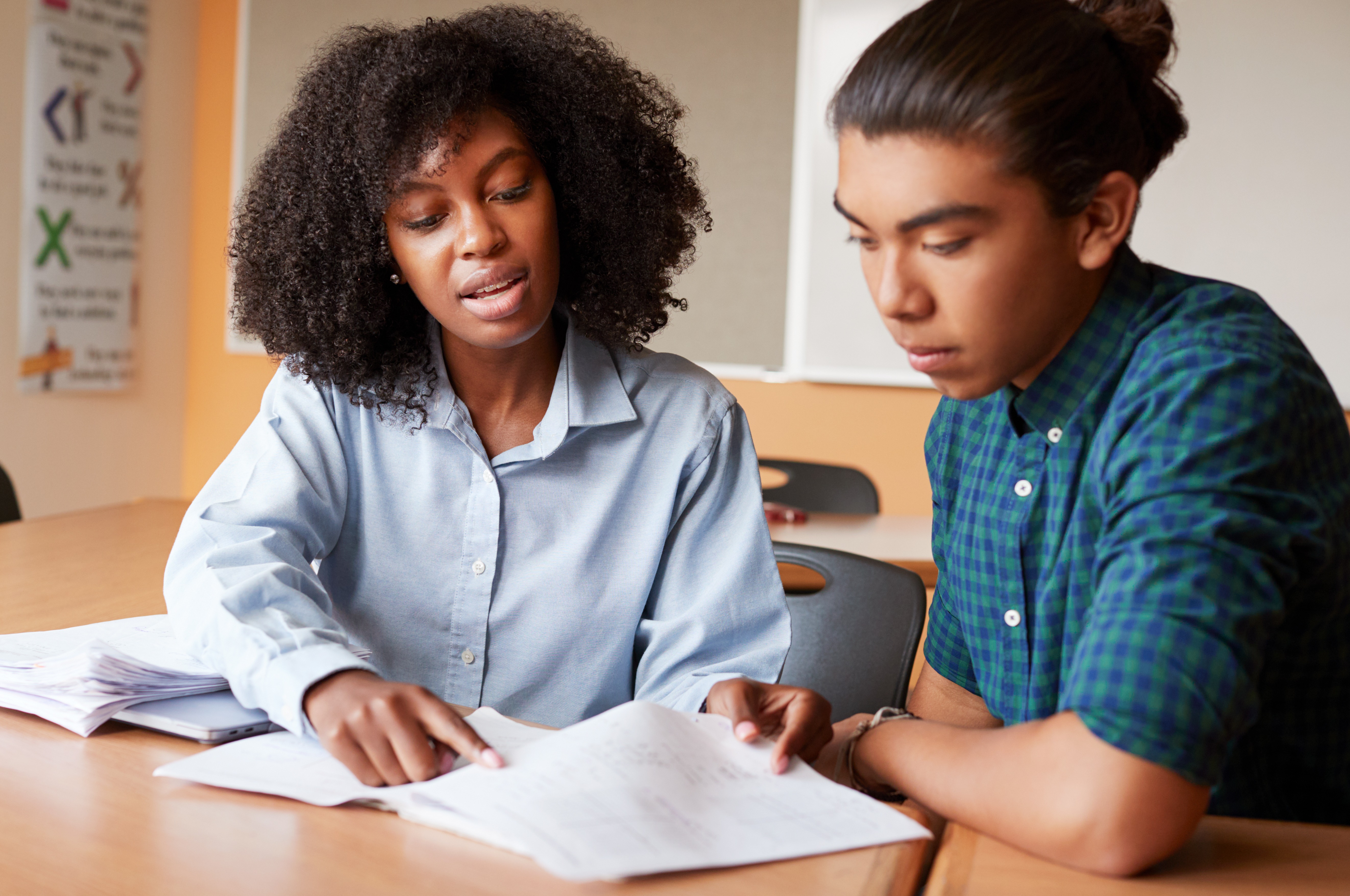 high school tutor with male student in classroom