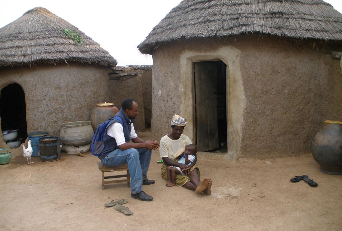 Savings client talks with surveyor in Ghana