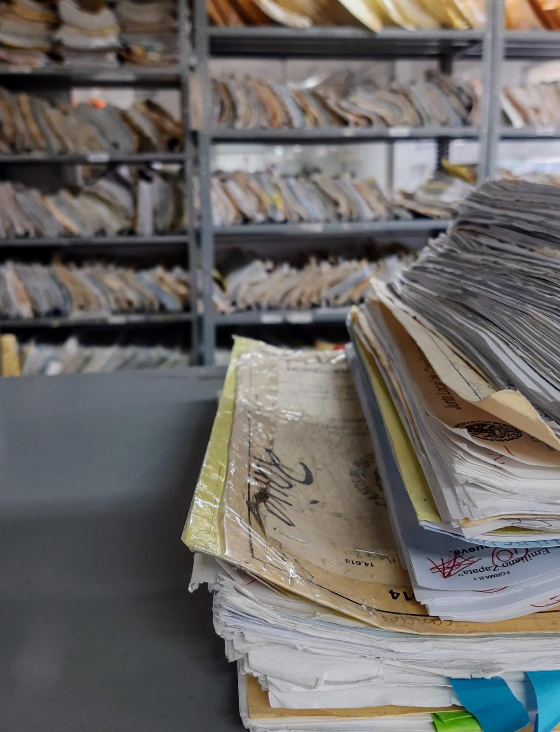 A stack of case files in a room full of files.