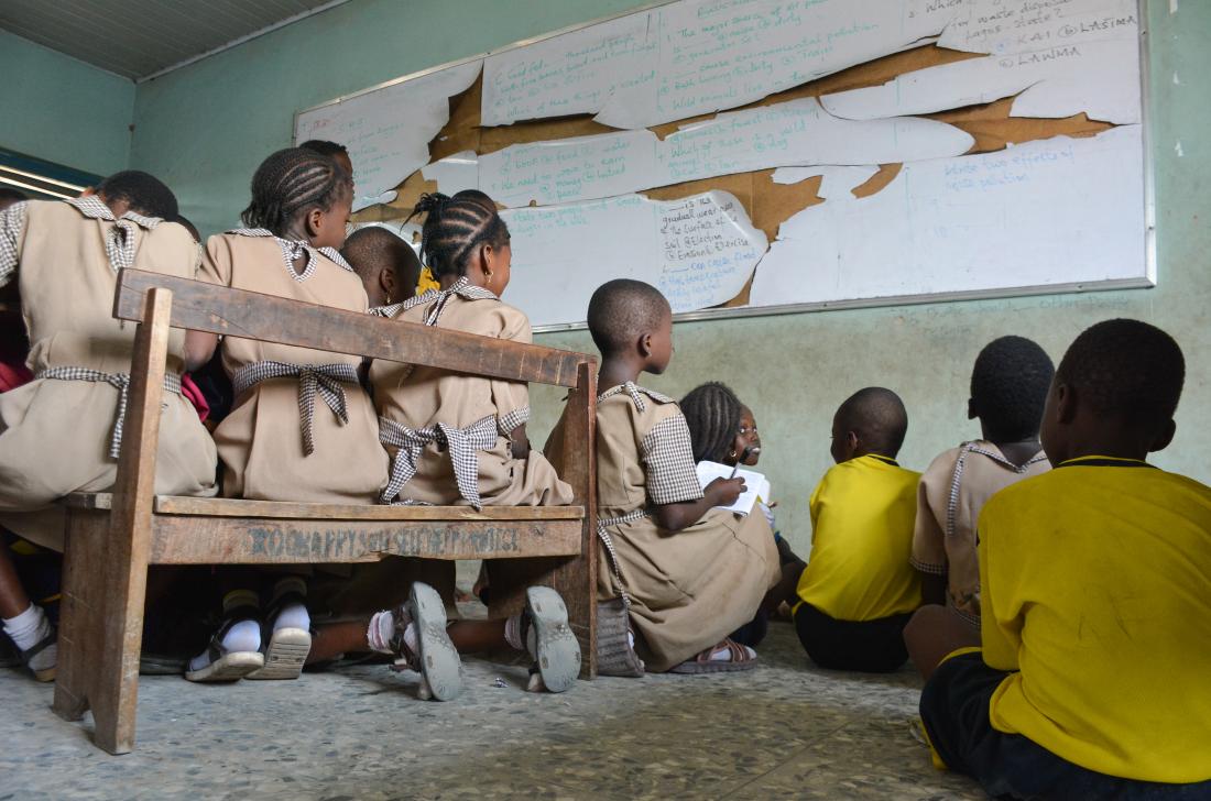 Nigerian children sitting on floor of classroom