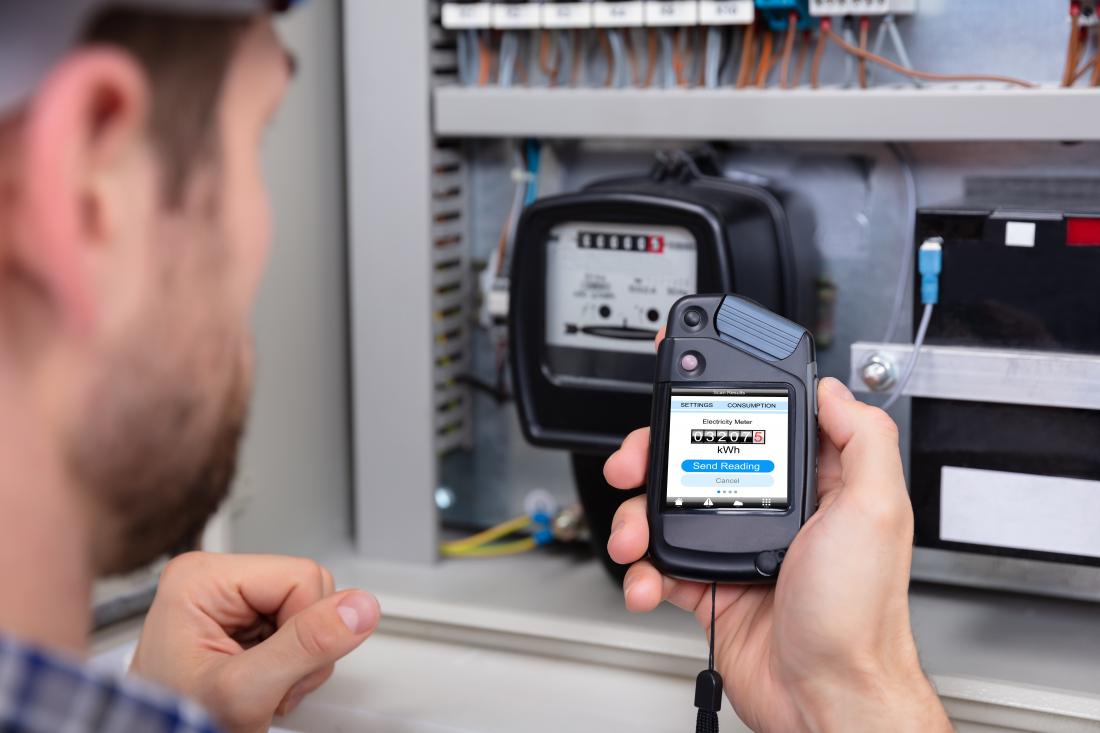 close up of a male technician reading an electric meter