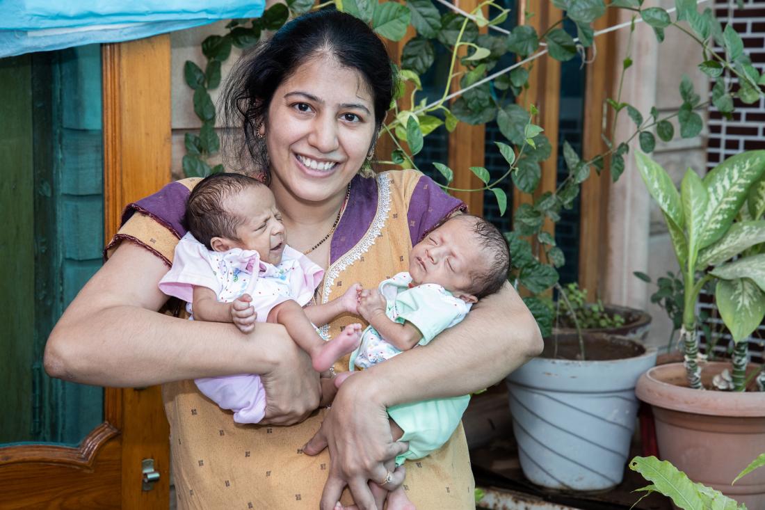 mother holding twin babies