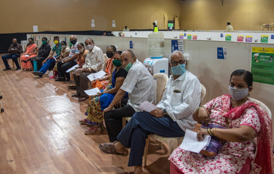 senior citizens wearing masks waiting for the Covid-19 vaccine
