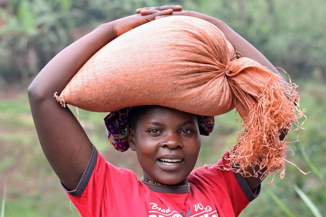 young Rwandan woman carrying a sack on her head