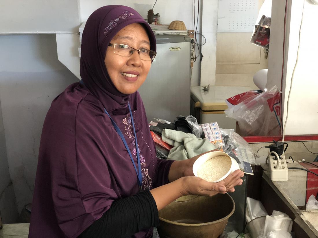 A woman holds a bowl of rice