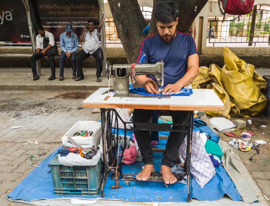 tailor working with sewing machine outdoors