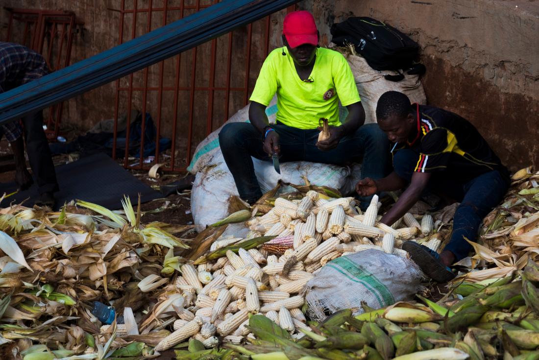 Man in Uganda selling maize 