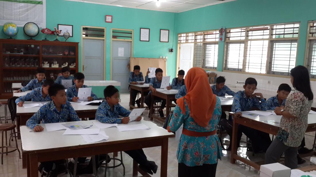An instructor reads to students in a classroom