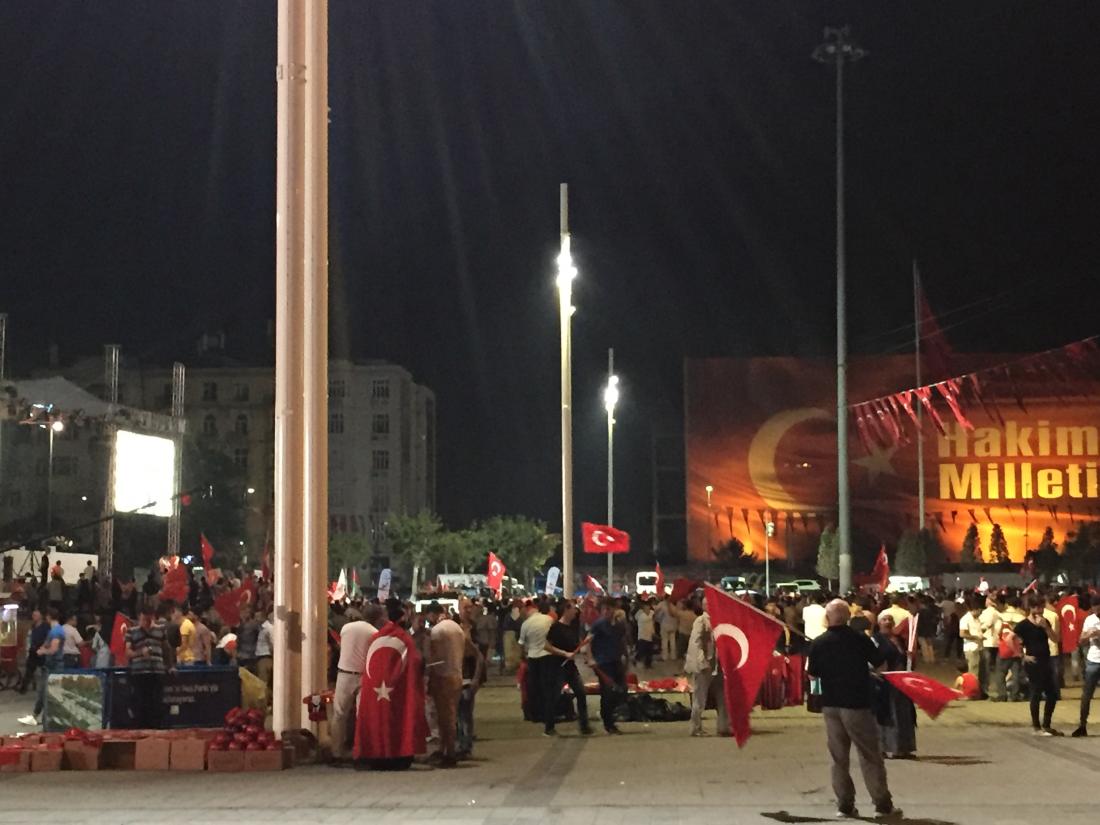 Turkish citizens gather at night in Taksim square with Turkish flags