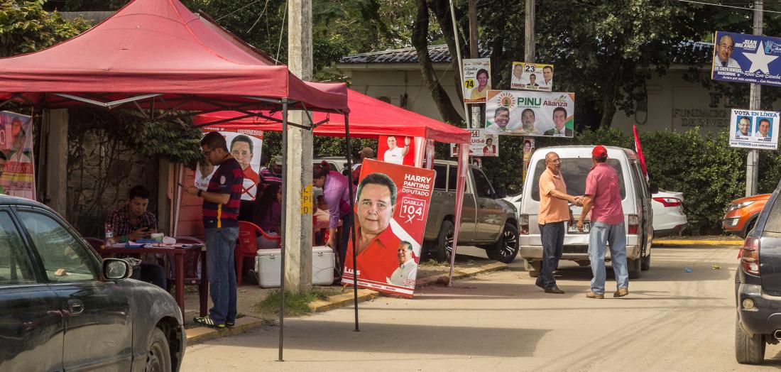 Image of voters stopping by political party booths in Honduras.