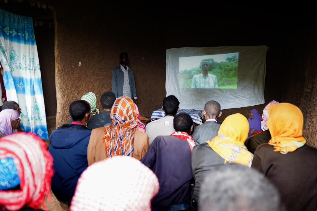 Extension worker plays video in training