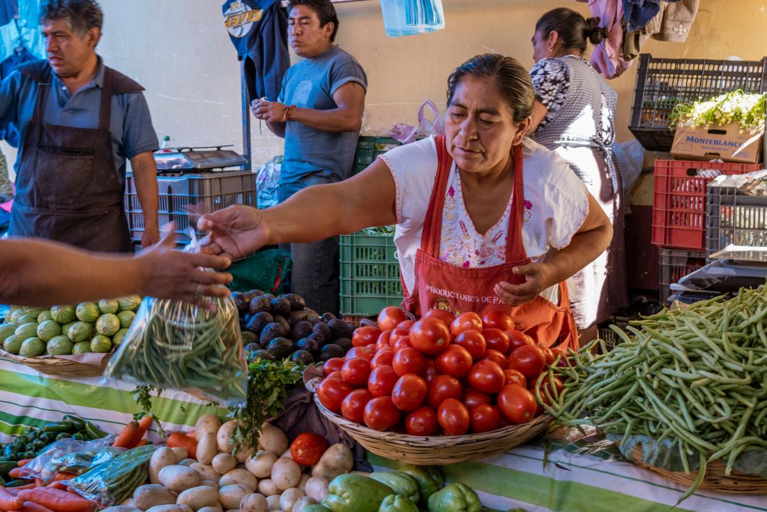 A woman merchant is selling vegetables