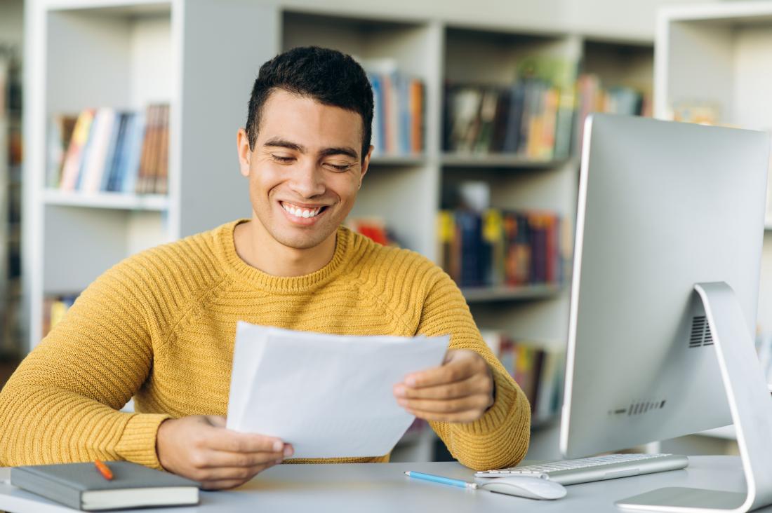 Young man smiling at letter