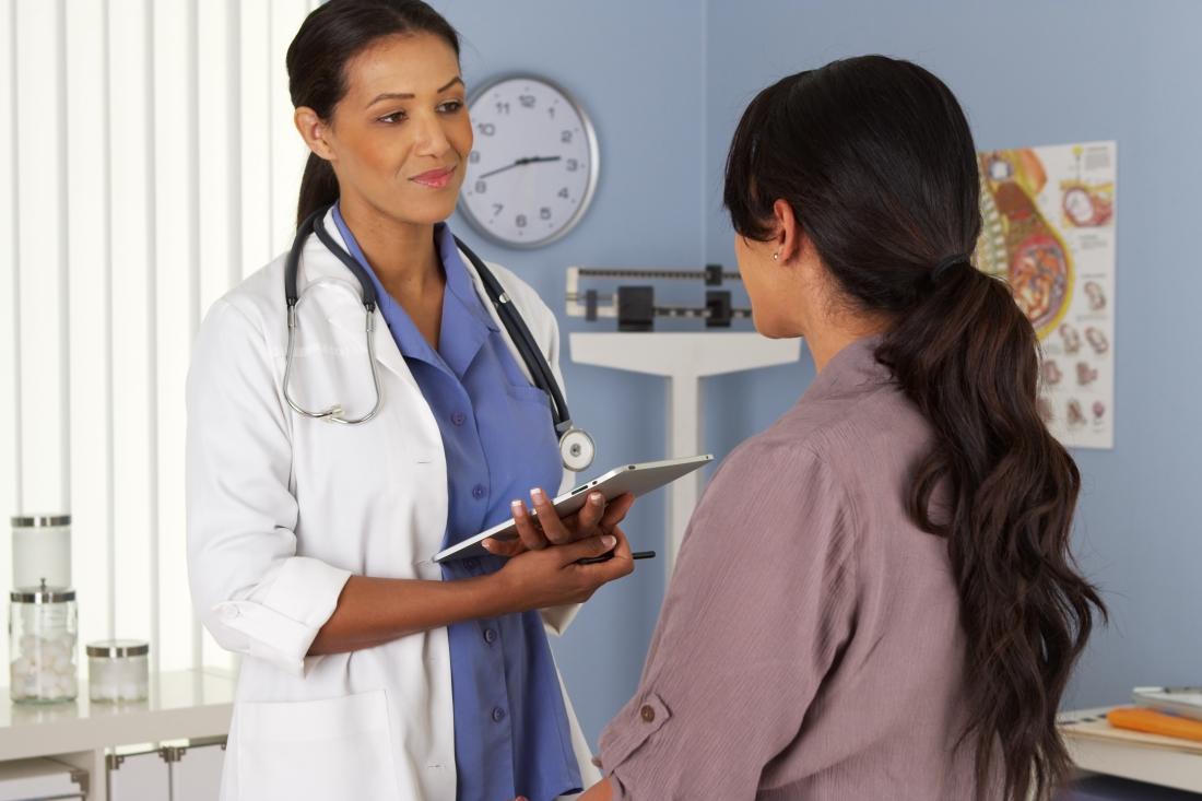 Woman in sitting in a medical office talking to her doctor