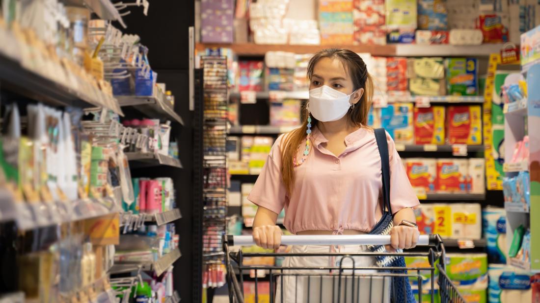 Woman in mask shopping for groceries