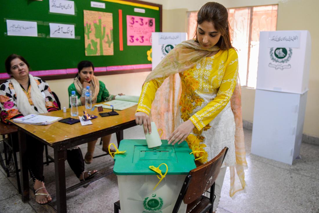 A voter casts her vote at a polling station during the by-election in Lahore, Pakistan, October 14, 2018