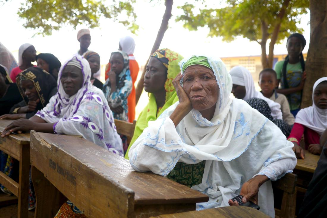 Women gather for a community meeting in Ghana, J-PAL Africa evaluation summary
