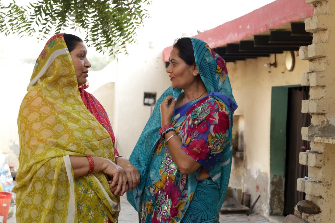 Two women spreading information through word-of-mouth in India