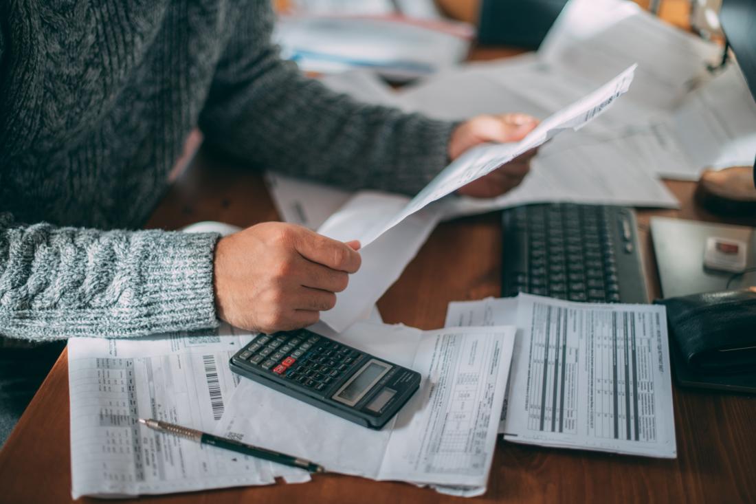 A man with long sleeve shirt ensures tax compliance by reviewing tax paperwork in Bangladesh
