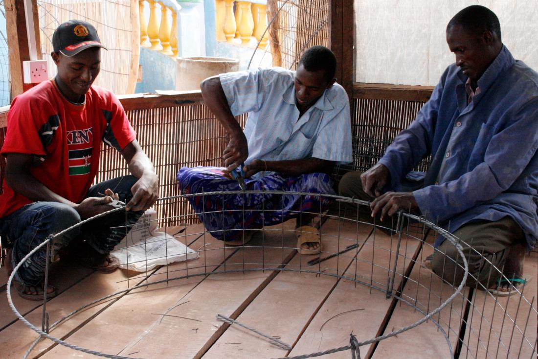 Three men assemble a metal well frame J-PAL Africa evaluation summary