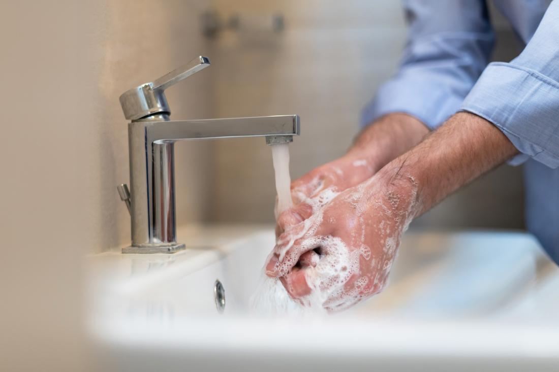A man washes his hands with soap. 