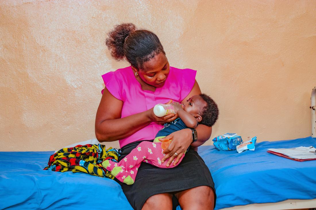 A mother bottle feeds her baby in Nigeria. 