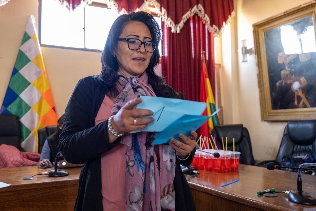 An OTB president reads from paper and explains public good provision in Bolivia.