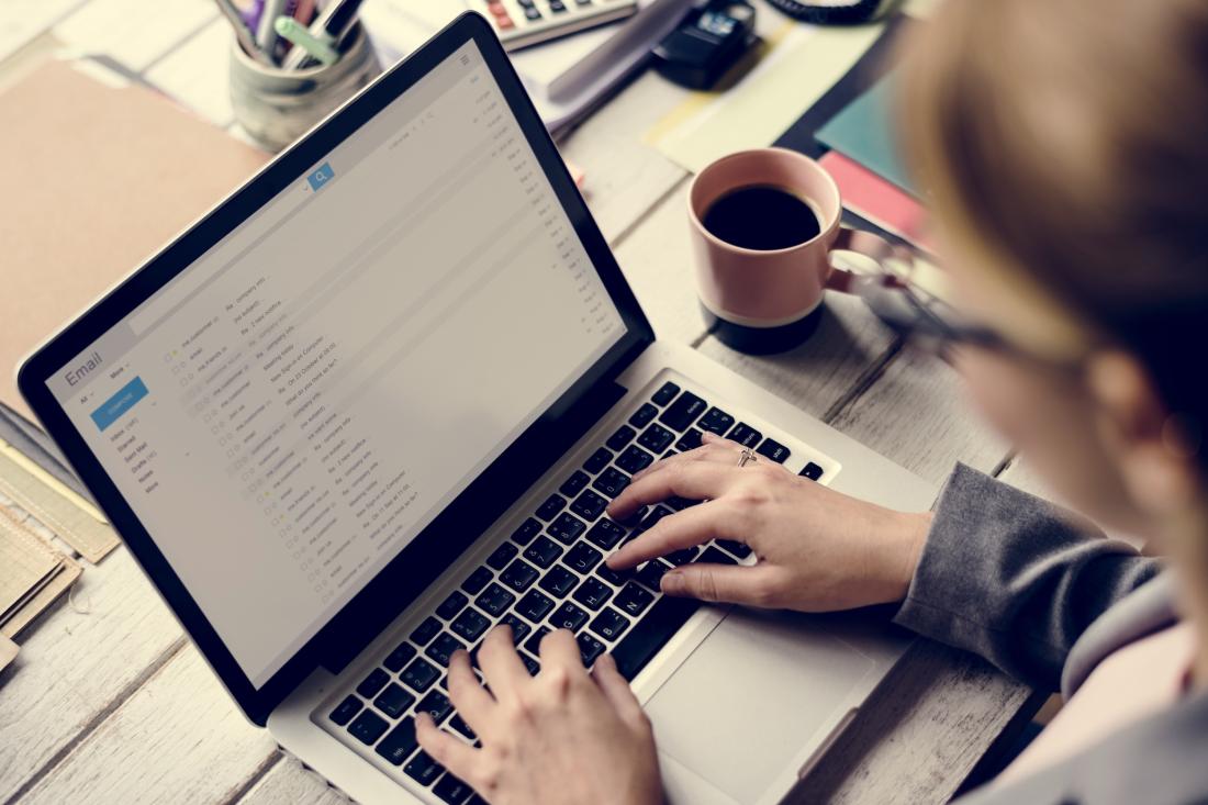 A woman wearing glasses checks her emails in the United States