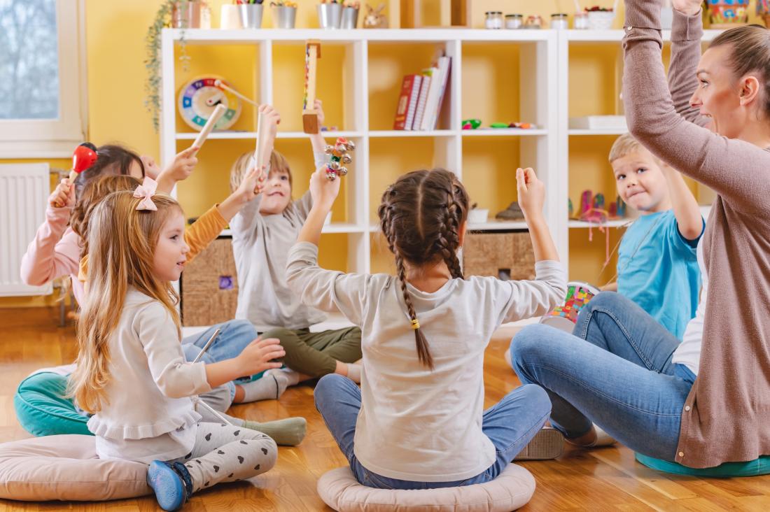 Kindergarden students play with their teacher in a classroom in the United States
