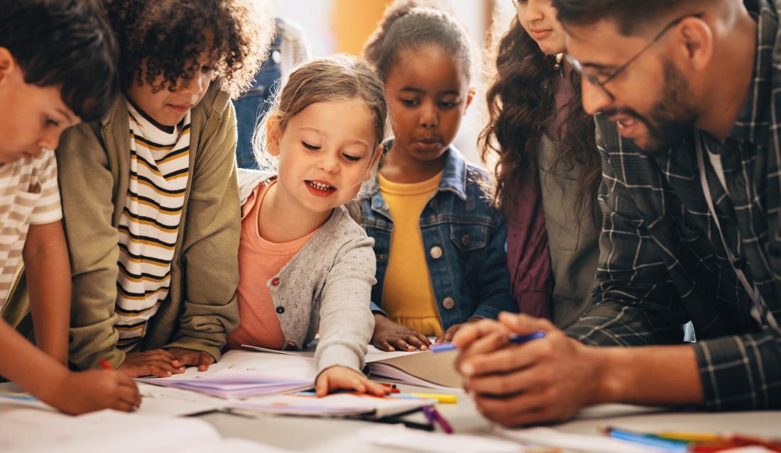 Elementary school students engage in group activity with teacher in the United States