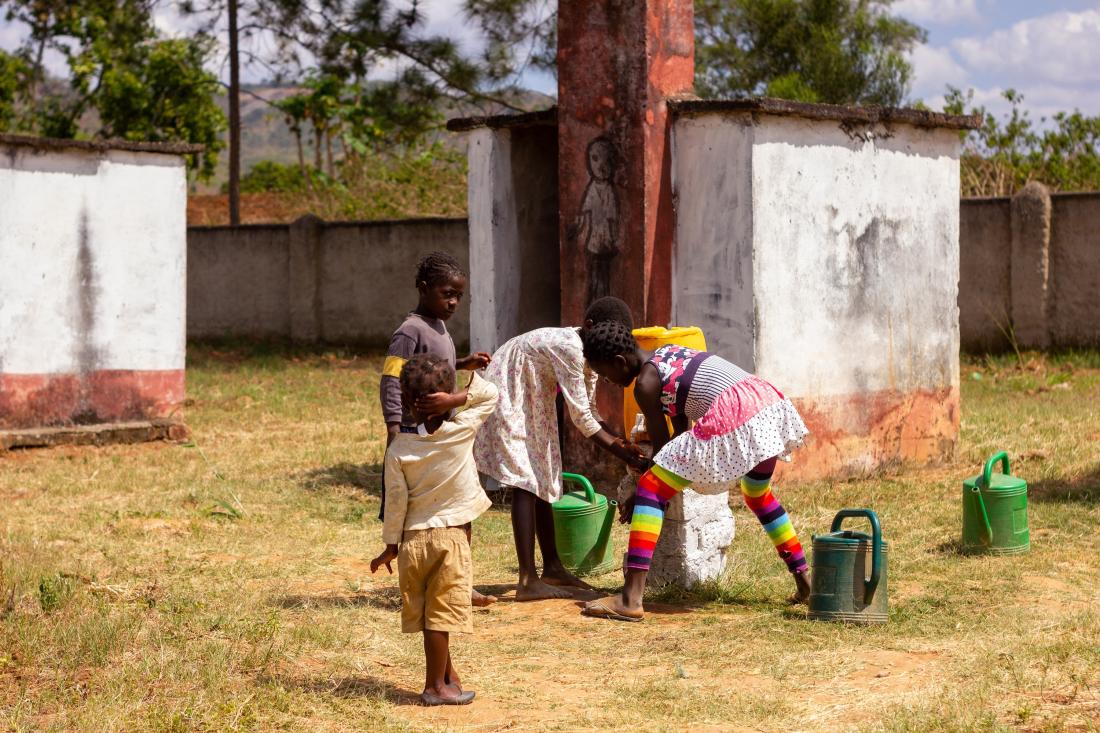 Group of children using sanitation service to wash hands in Senegal