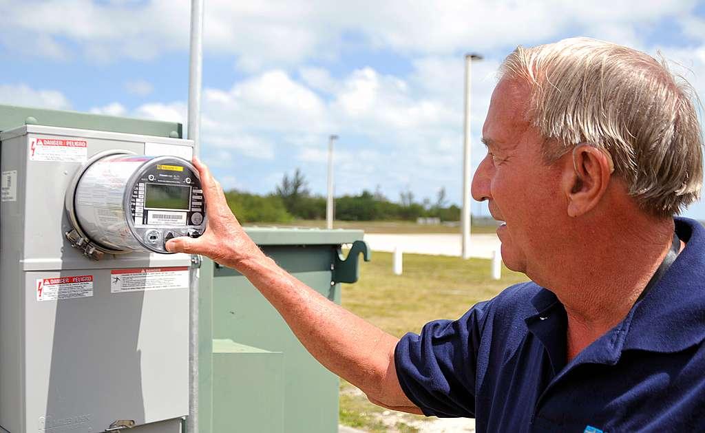 Professional pressing button on smart meter in an open space outdoors.