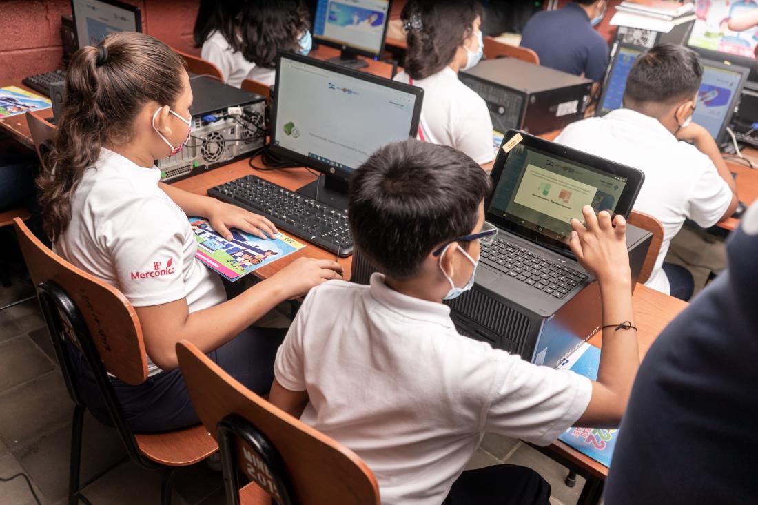 Children going through computer assisted learning in classroom in Colombia