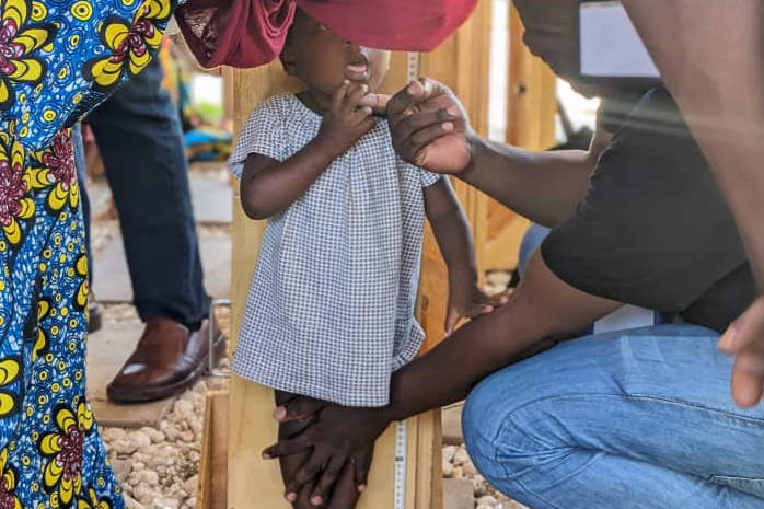 A doctor measures the height of a child.