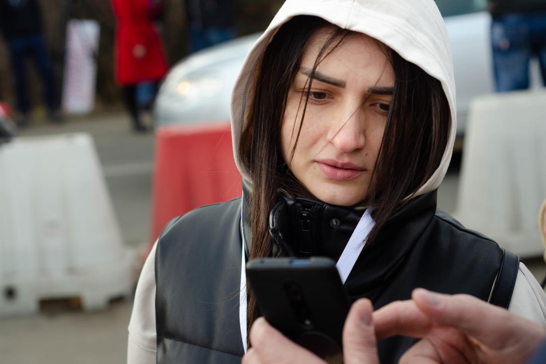 Someone showing young Ukrainian women resource on smartphone