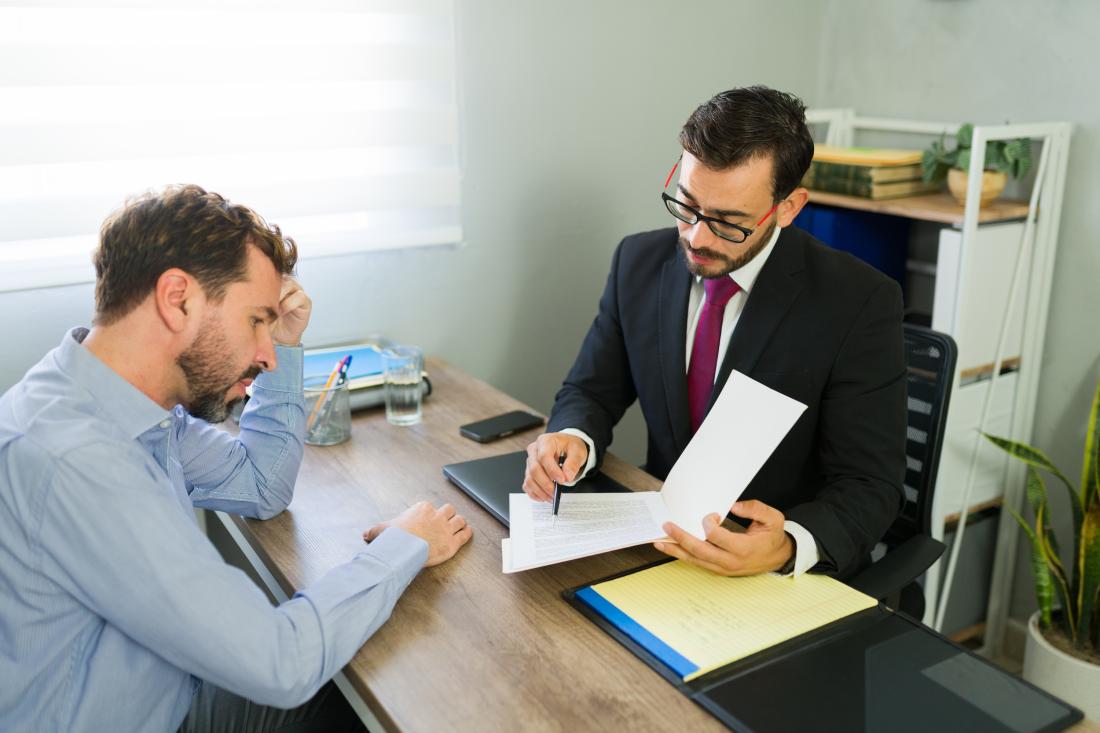 Defendant consulting with legal counsel in an office.