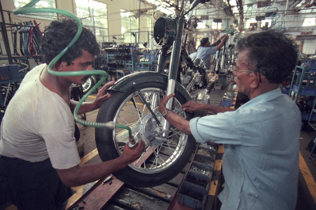 Two men work in a motorcycle factory in Chennai, India