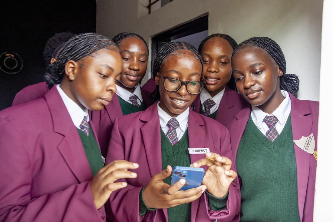Students look at a phone together in Lusaka, Zambia. 