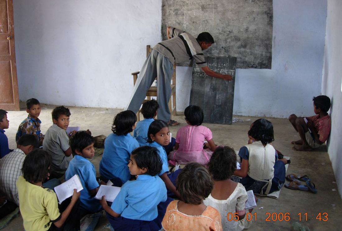 Indian children sitting on the floor of a classroom