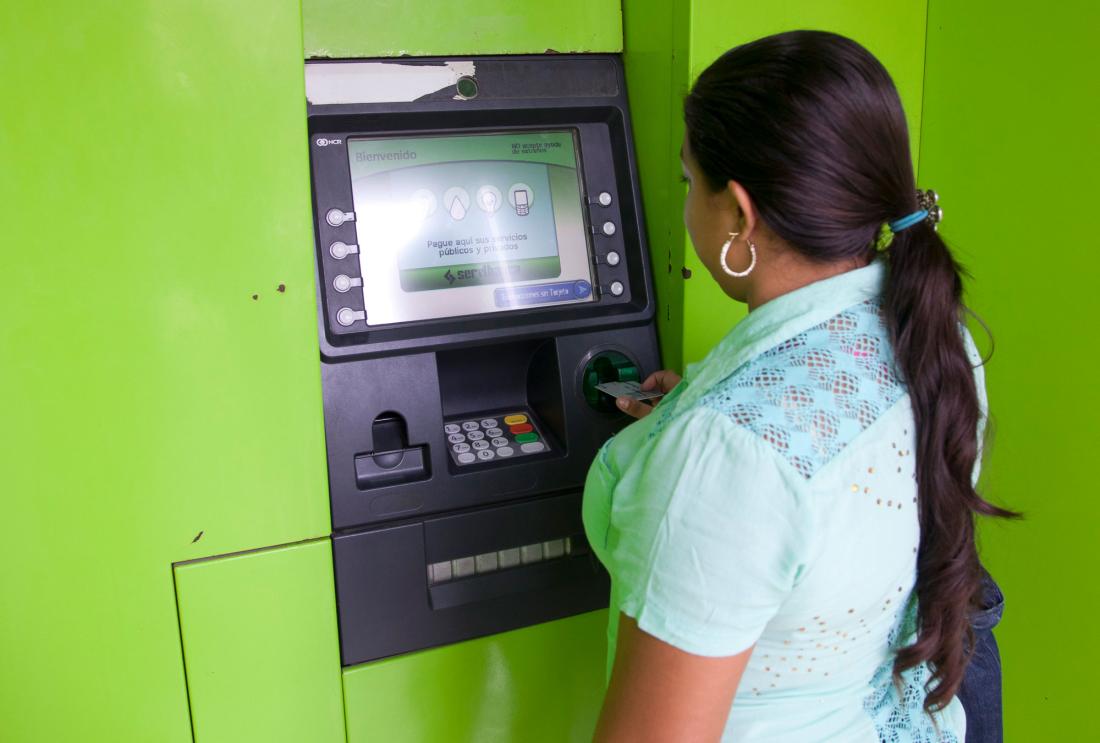 A woman withdraws cash from an ATM