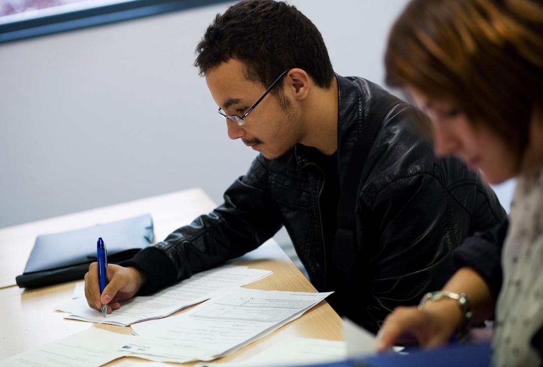 Man in glasses writes on papers