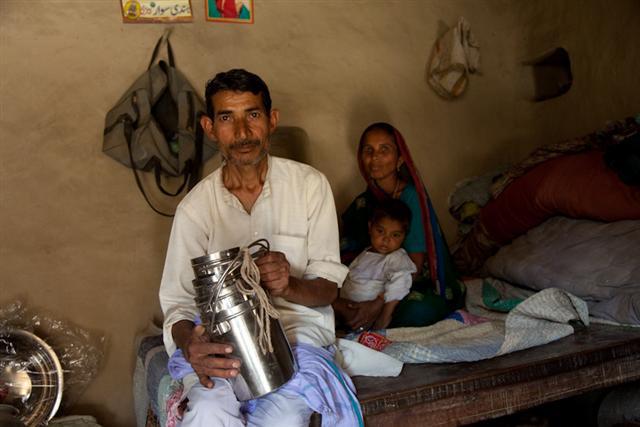 Indian man pictured with his family and his wares