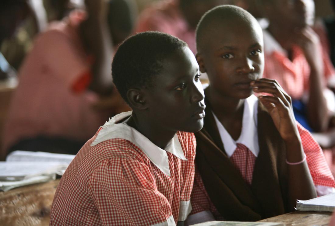 Girls in school uniforms sit in class