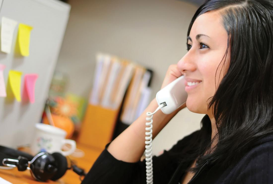 Smiling woman at work on the phone