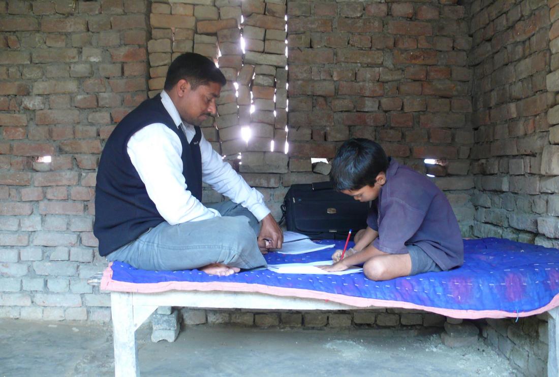 A father helps his son with his homework.