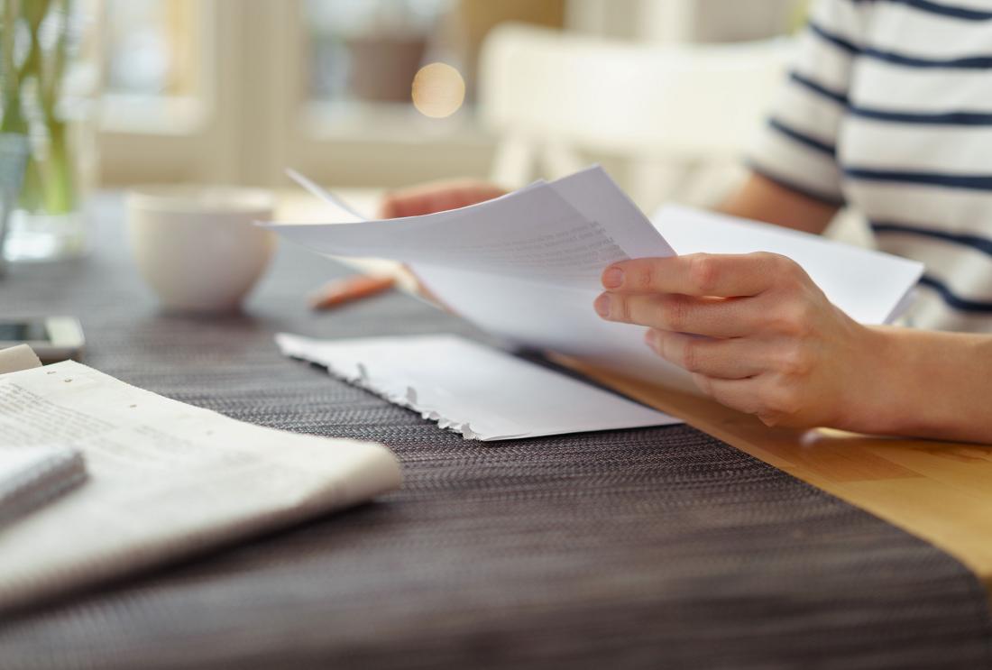 Hands hold a letter next to opened envelope